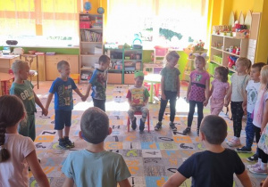 Dzieci ustawione w kole śpiewają Stefanowi sto lat